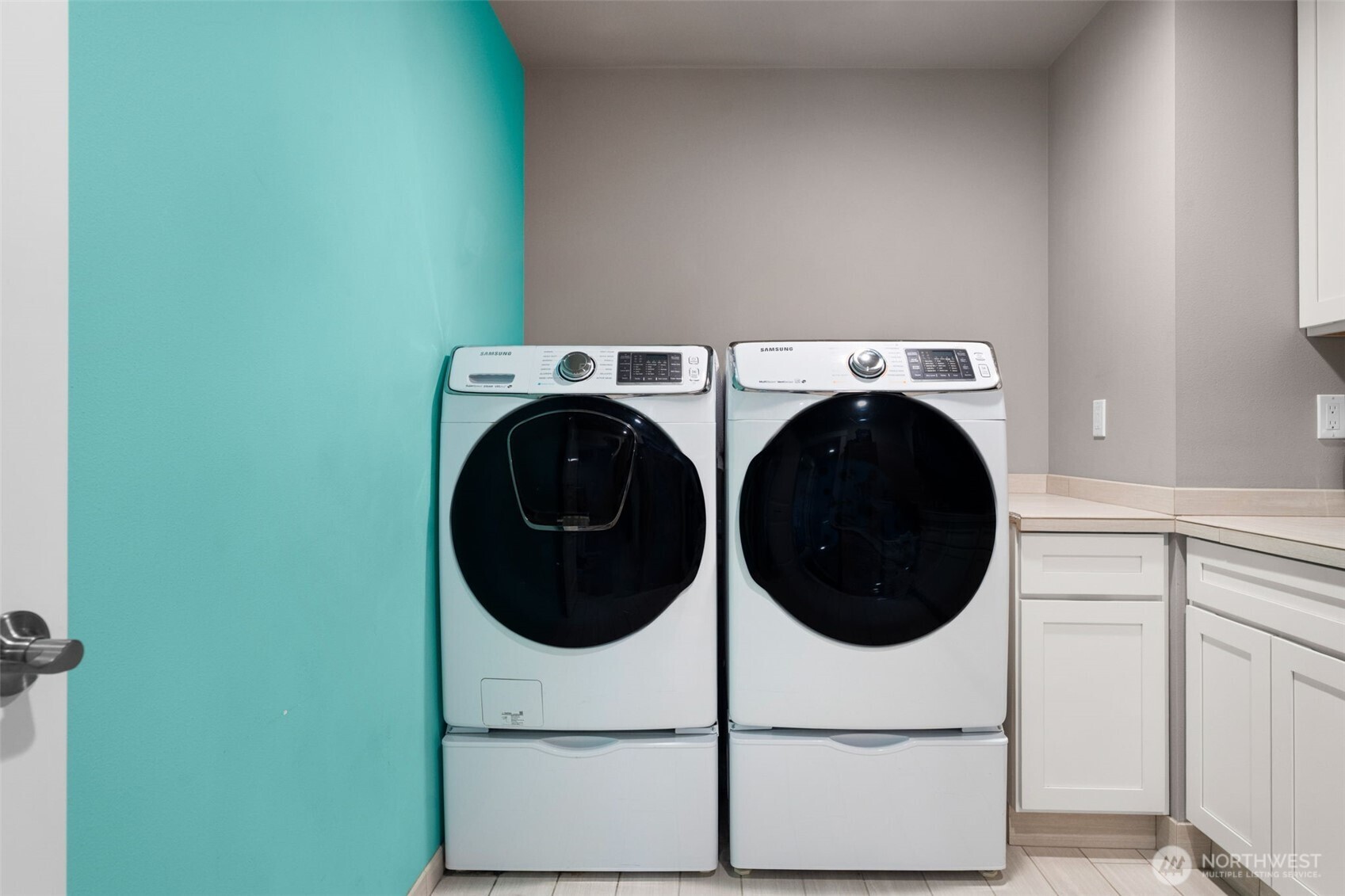Laundry room with side-by-side washer and dryer and built-in utility sink.
