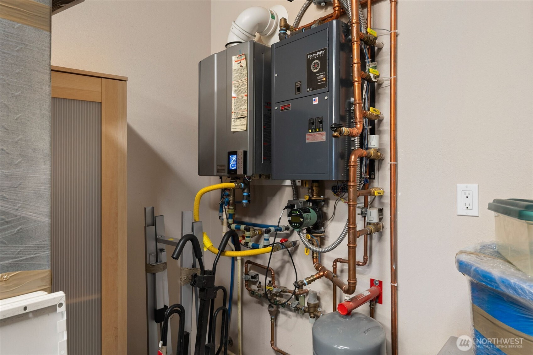 Home systems area featuring a tankless water heater and radiant floor heating components.