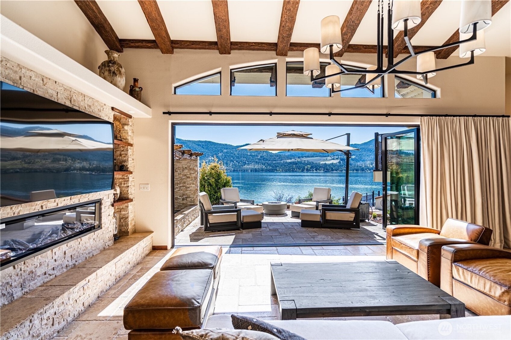 Luxury living room with panoramic windows framing the lake and Cascade mountains.