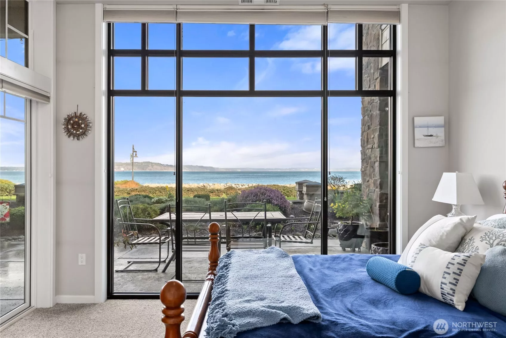 Wake up to breathtaking waterfront views from this serene bedroom retreat. Floor-to-ceiling windows fill the space with natural light and frame stunning views of the Puget Sound, while the private patio just beyond offers the perfect place to relax and enjoy the coastal surroundings.