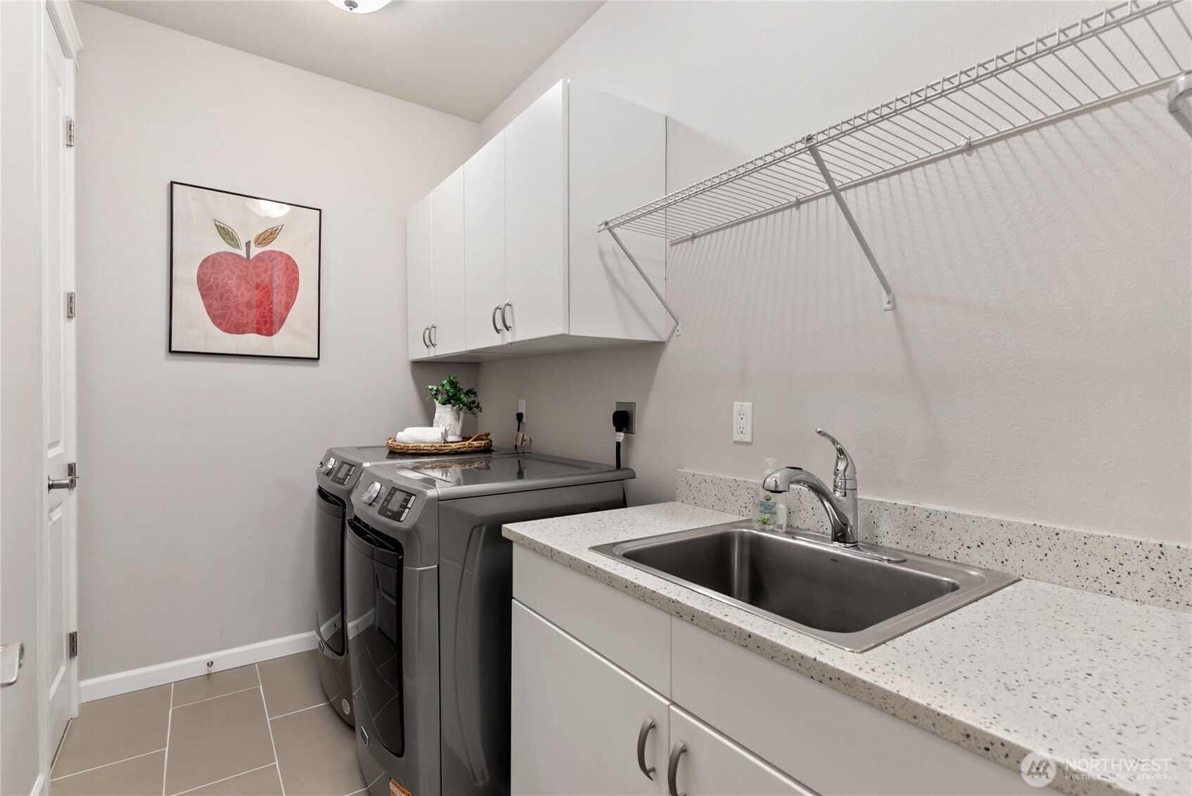 Spacious laundry room with new washer/dryer combo. Includes a convenient deep sink hanging space and enough counter space to fold.