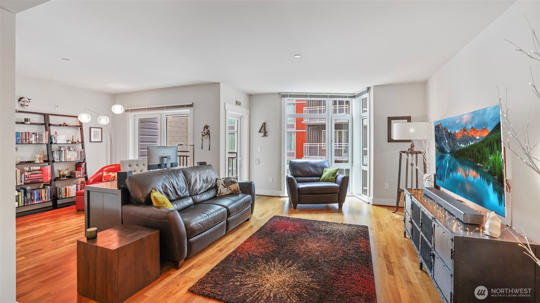 Living room with floor to ceiling windows, refinished walnut floors.