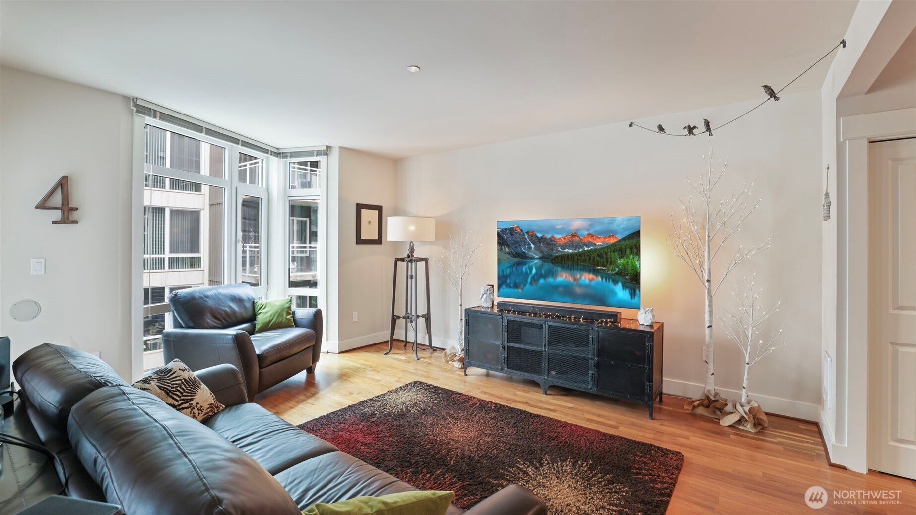 Living room with floor to ceiling windows, refinished walnut floors.