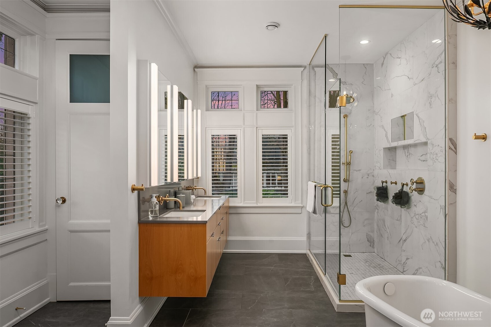 The primary bathroom has double vanities, an oversize walk-in shower, a soaking tub, heated floors and a separate powder room. Access to the roof deck is through a door to the left (not shown).