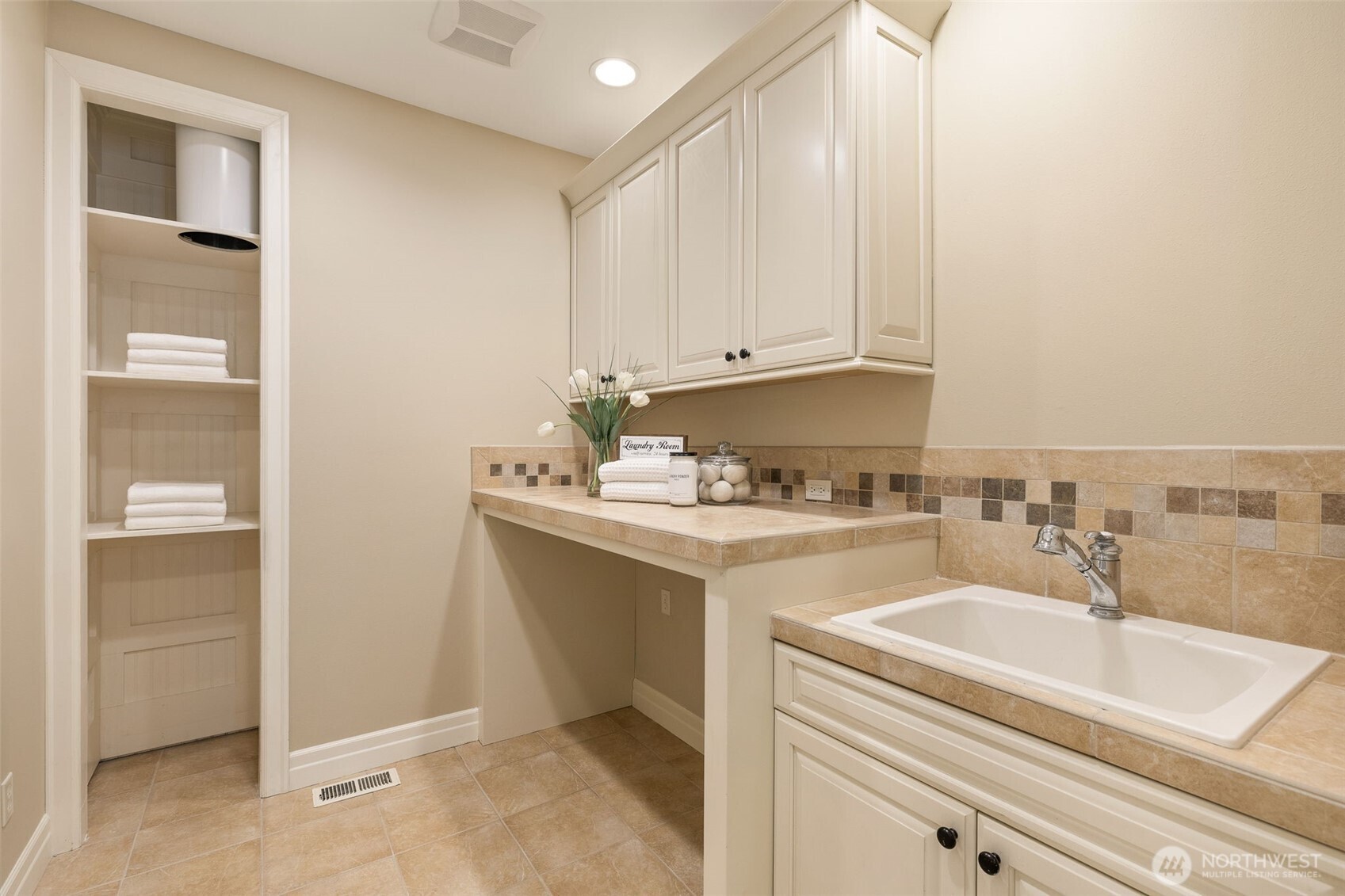 Laundry room with a laundry chute from the upstairs bath. There's another large storage closet on the left.