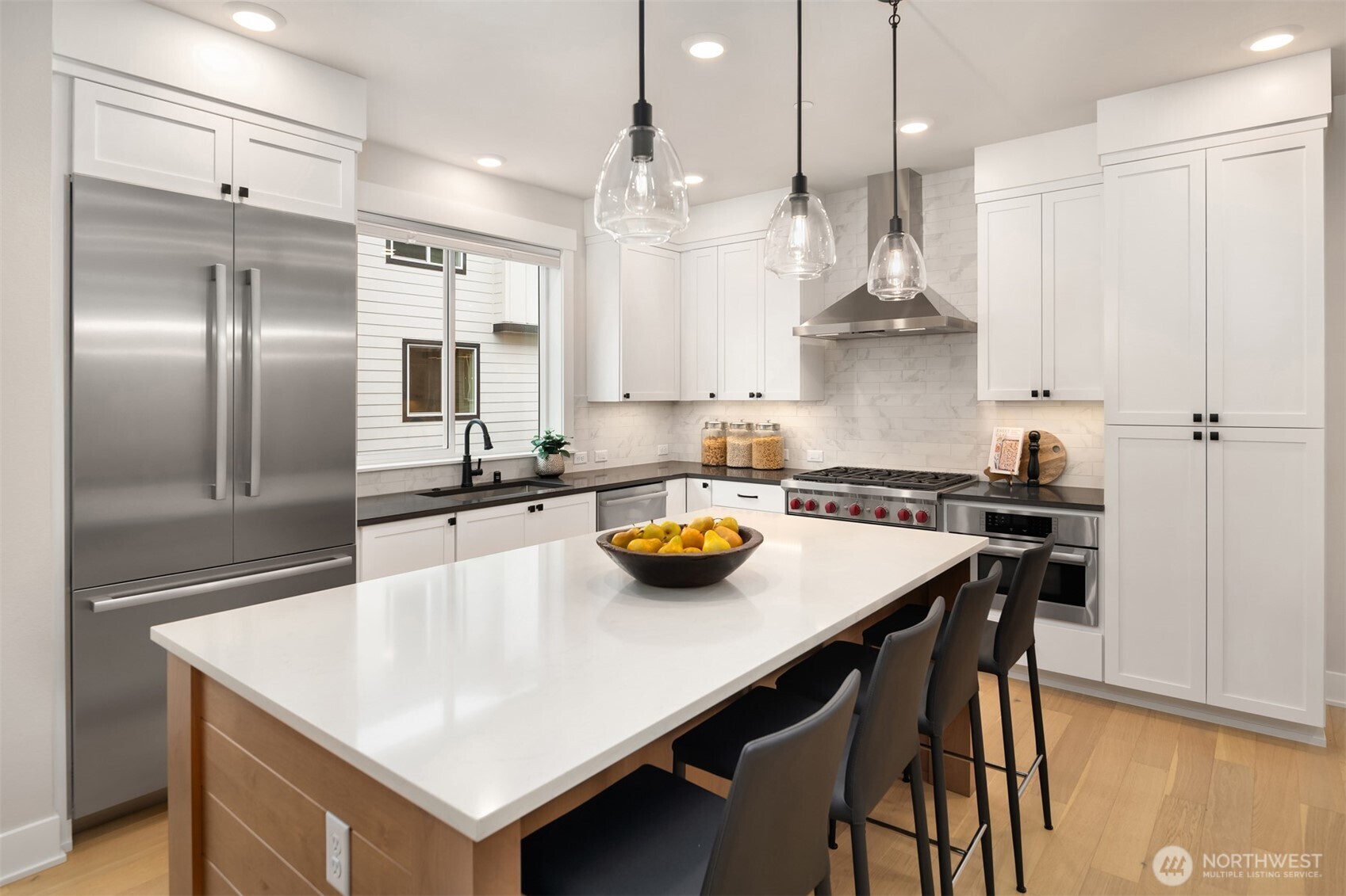 Premium kitchen with Wolf gas range, quartz island, and custom cabinetry.