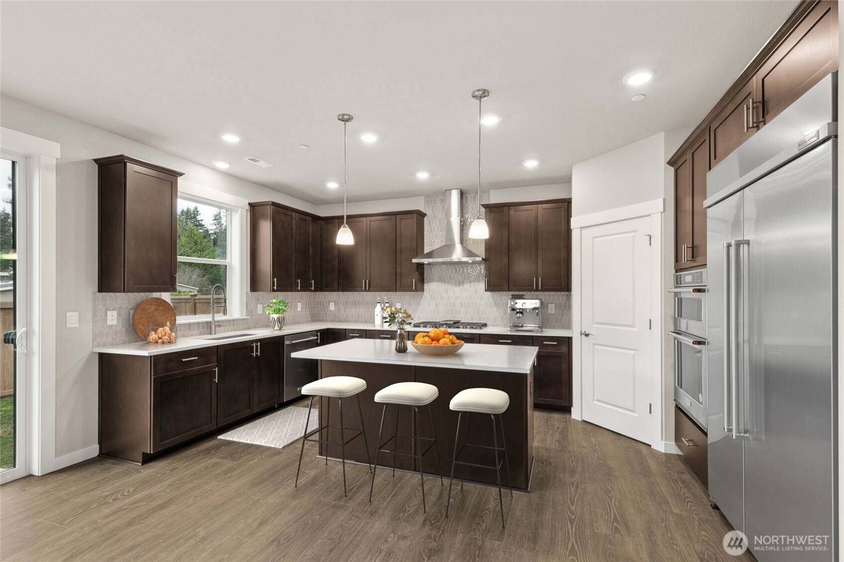 Virtually staged, well-appointed kitchen with gas cooktop & 48" side by side counter depth built in refrigerator. Home for sale will include white cabinetry.
