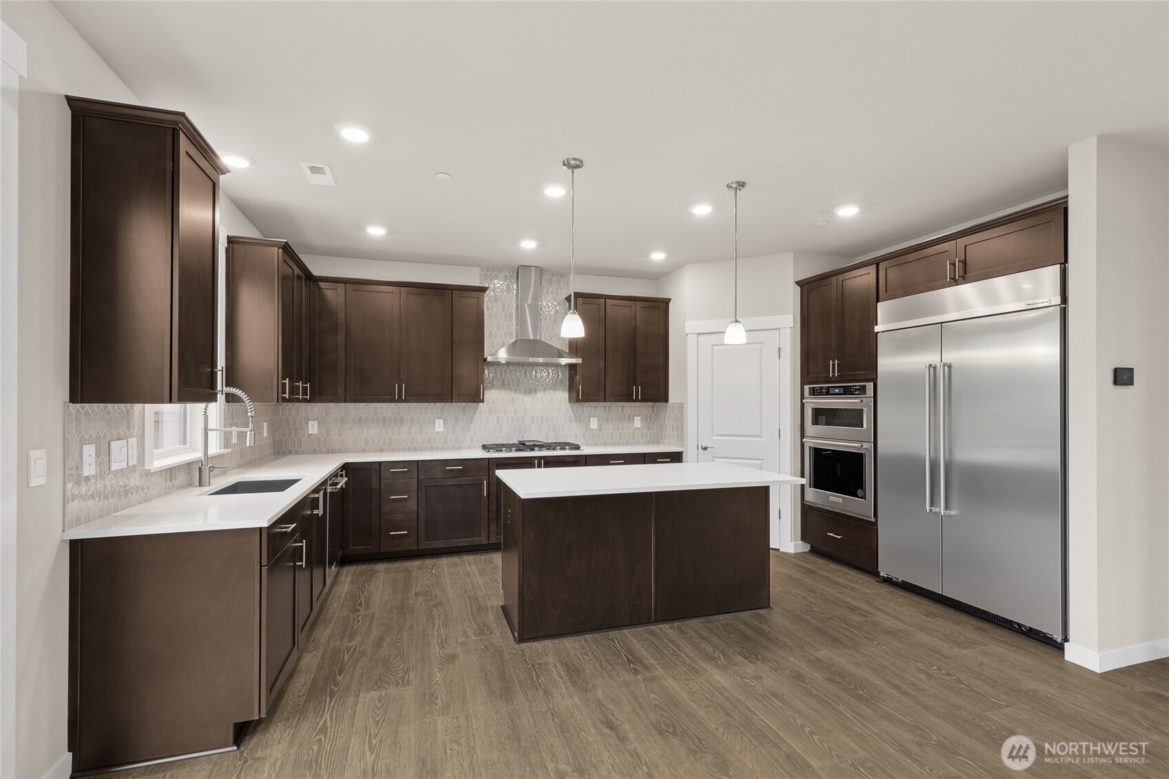 Well-appointed kitchen with gas cooktop, 48" counter depth side-by-side refrigerator. Plenty of space to entertain!  Home for sale will include white cabinetry.