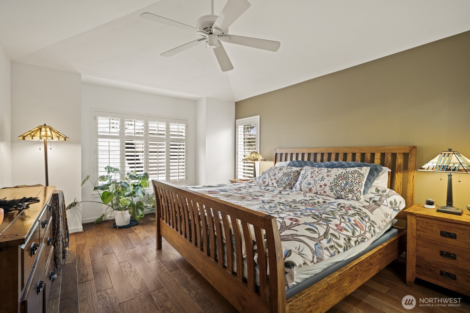 The primary suite boasts a tall vaulted ceiling with ceiling fan.