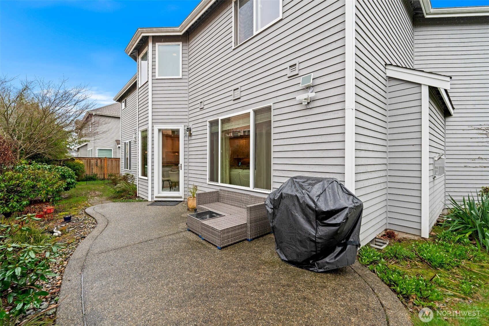 Sizable patio in fully fenced backyard with mature landscaping - a perfect place to relax and entertain.