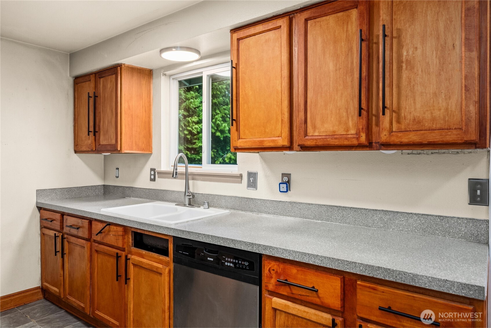 Kitchen window overlooks backyard