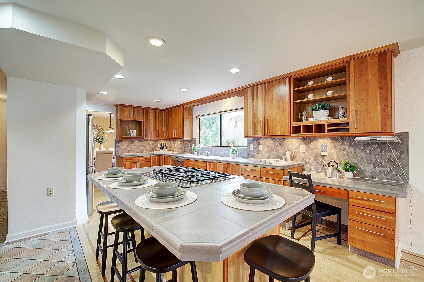 The custom kitchen includes built-in shelving for display and a desk for the home chef.