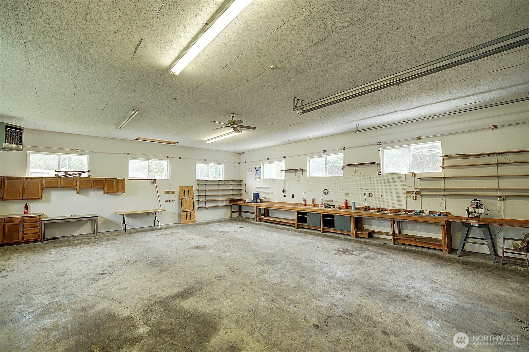 The shop interior is lined with work benches and also features a gas overhead shop heater.