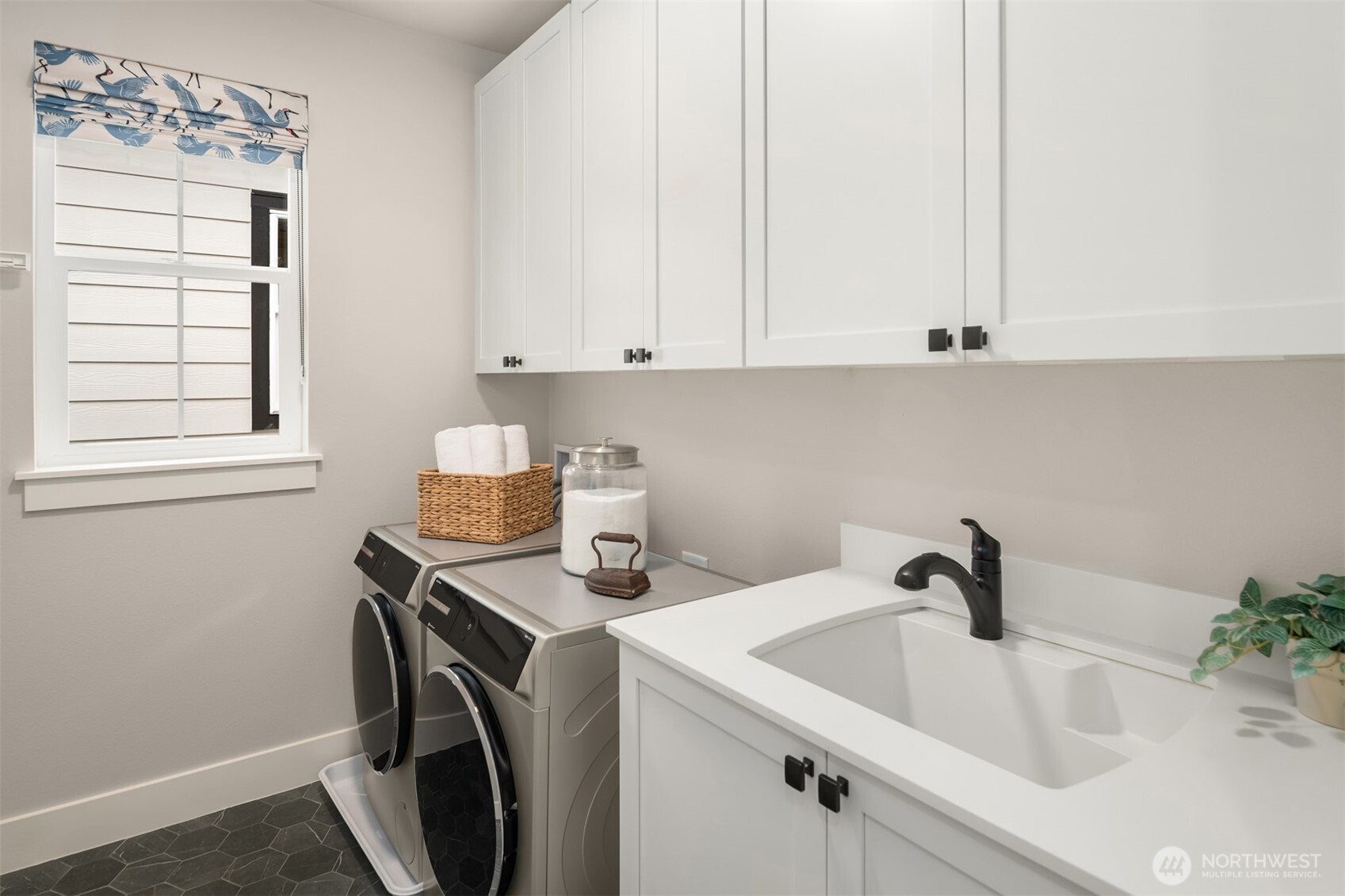 Convenient upstairs laundry room with built-in cabinetry and workspace.
