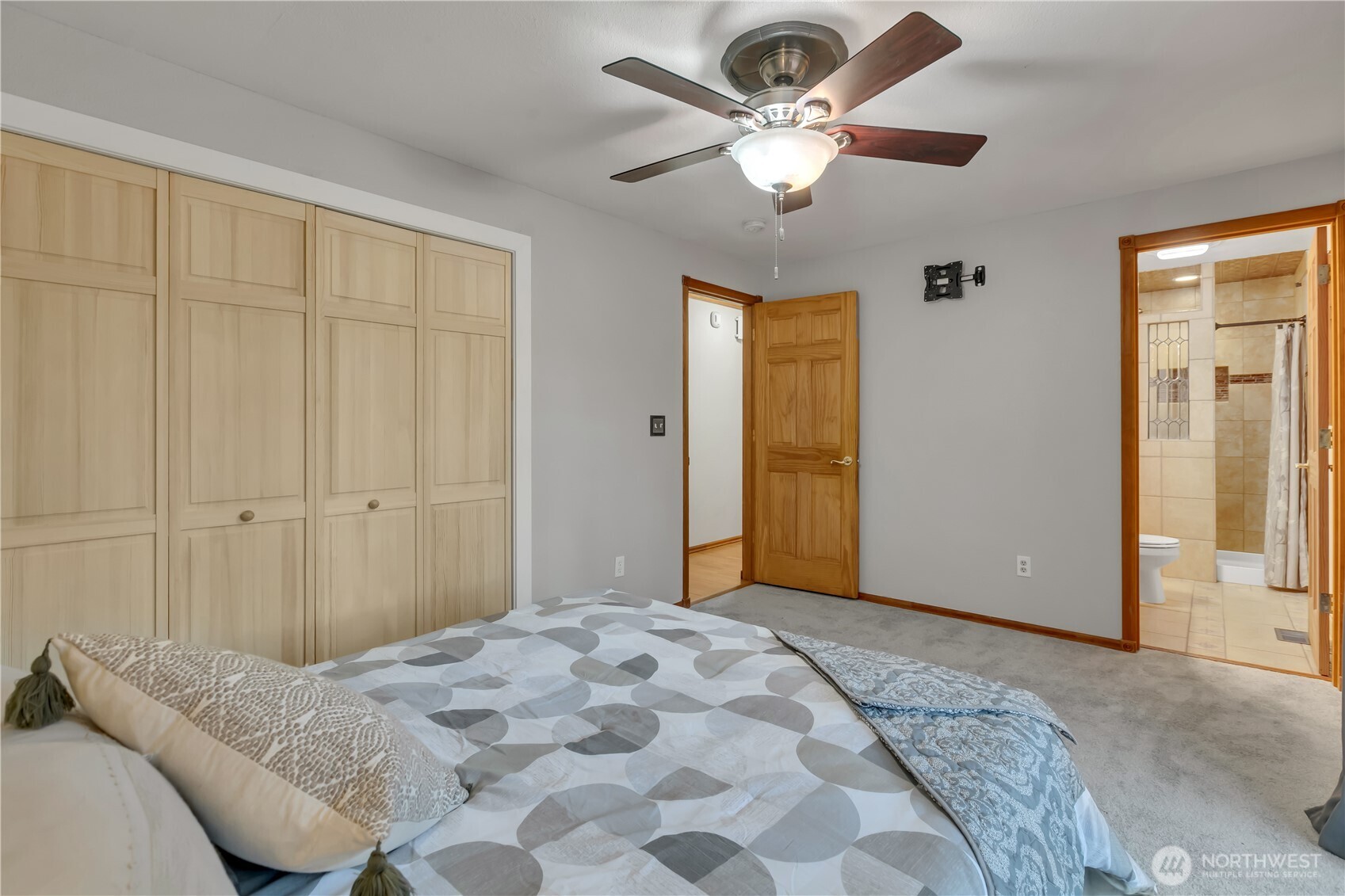 The primary bath has warm tile and a glass sink...