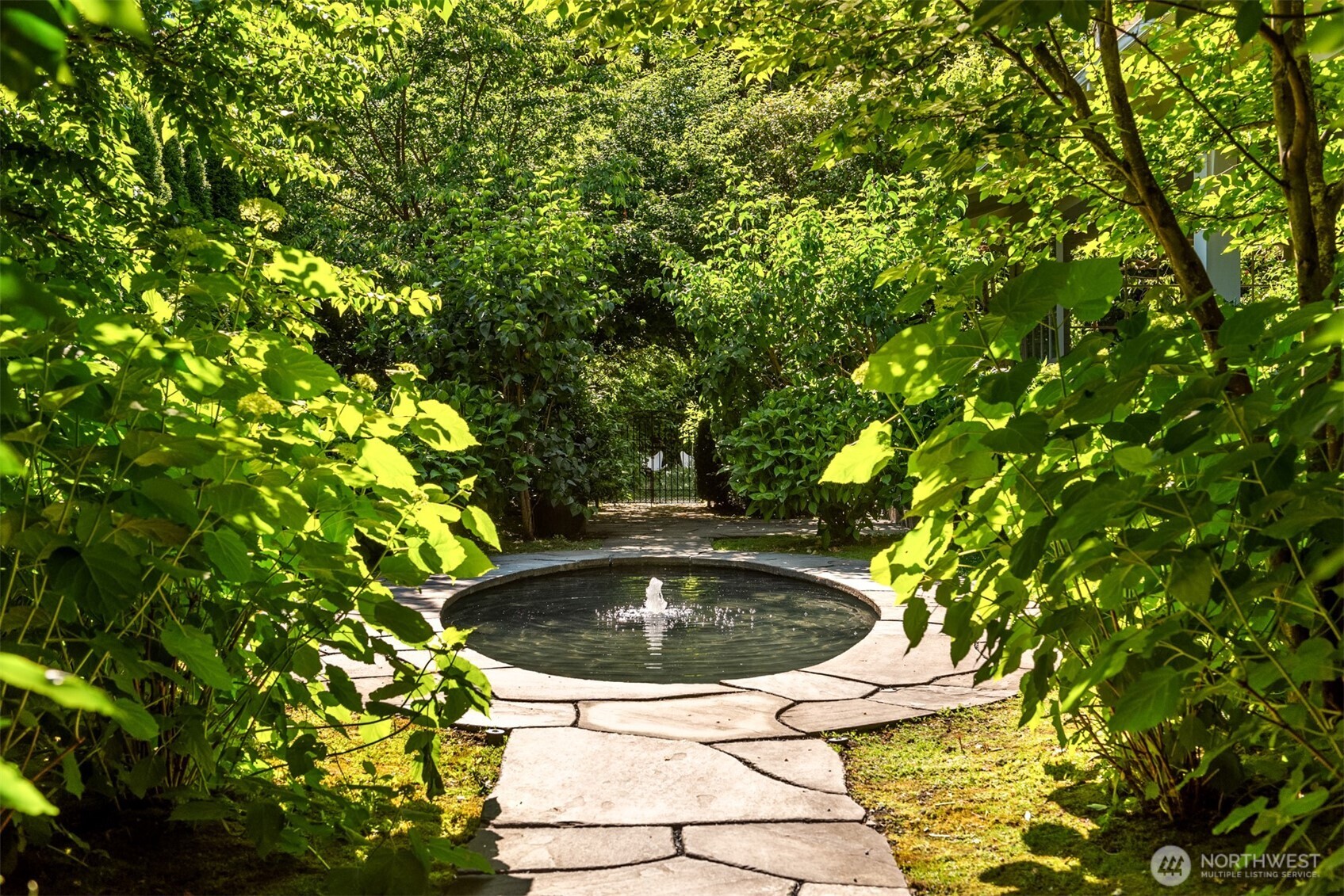 The elliptical pond welcomes guests and draws them through the garden layered with lavender, roses, hydrangea and espaliered apple trees.