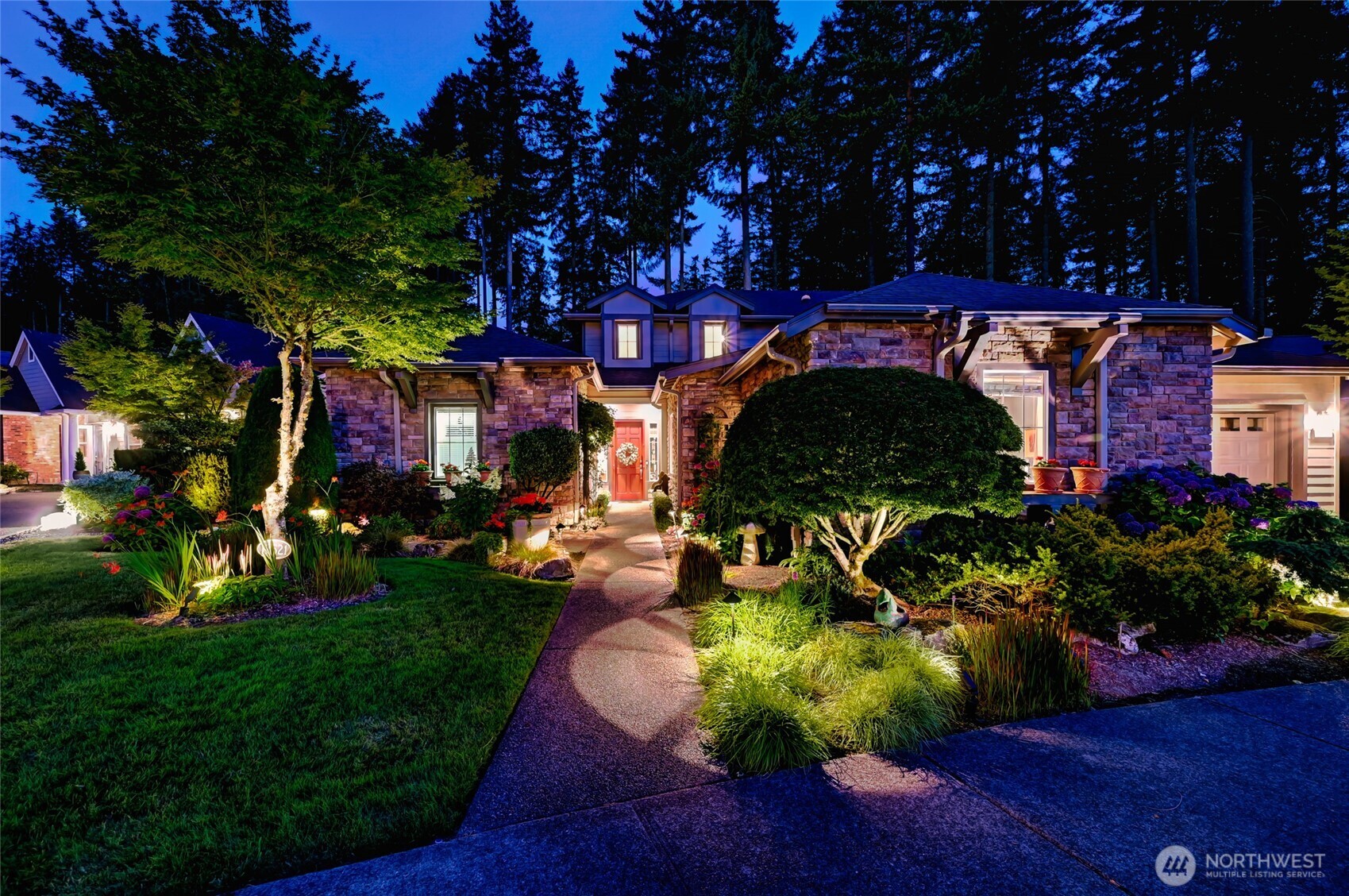 Stunning outdoor lighting highlights the gorgeous plantings in the yard.