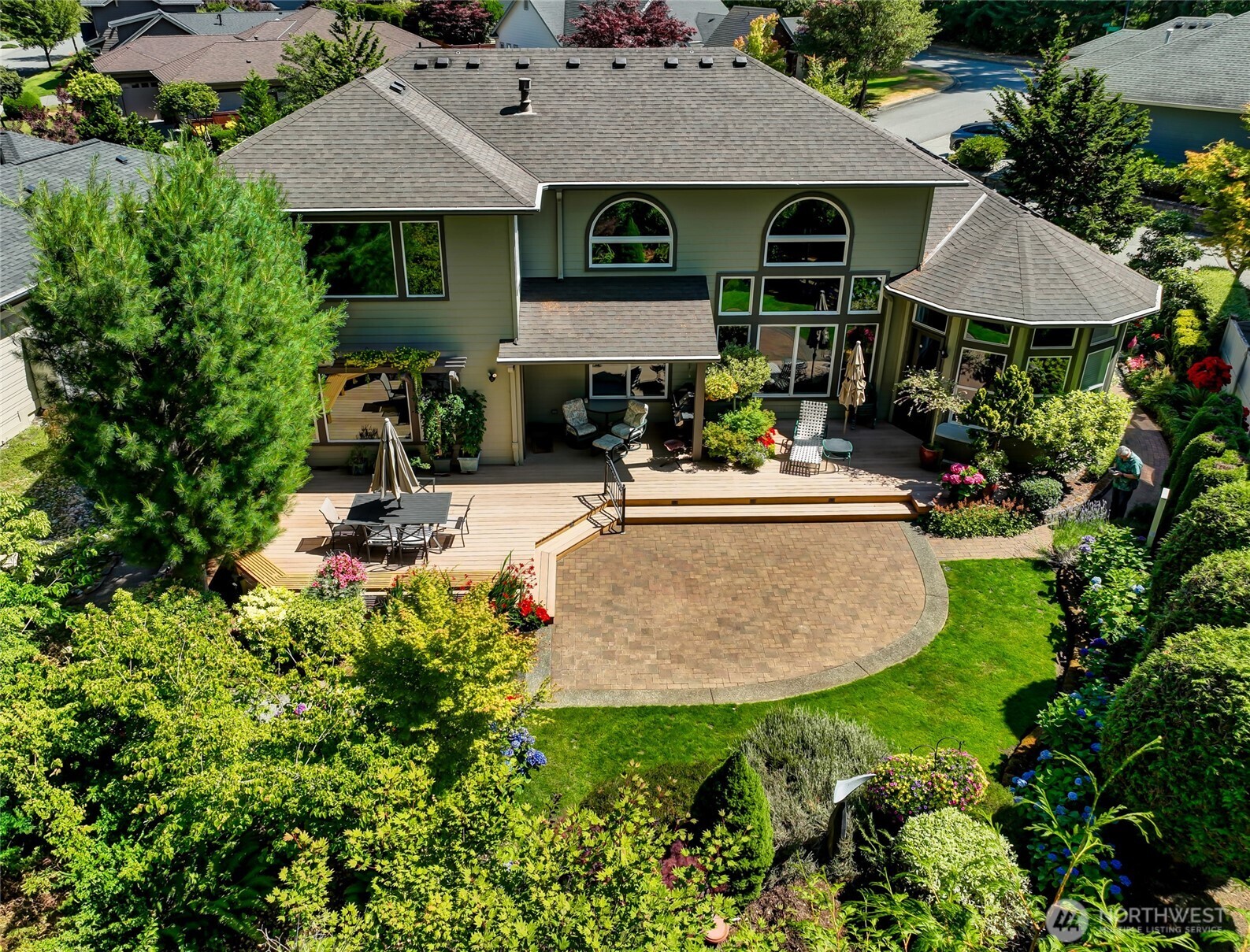 The sunny deck, with built-in benches, is a great place to entertain friends or relax on a summer afternoon. The deck steps down to the paver patio that leads to the paver path on the side of the home.