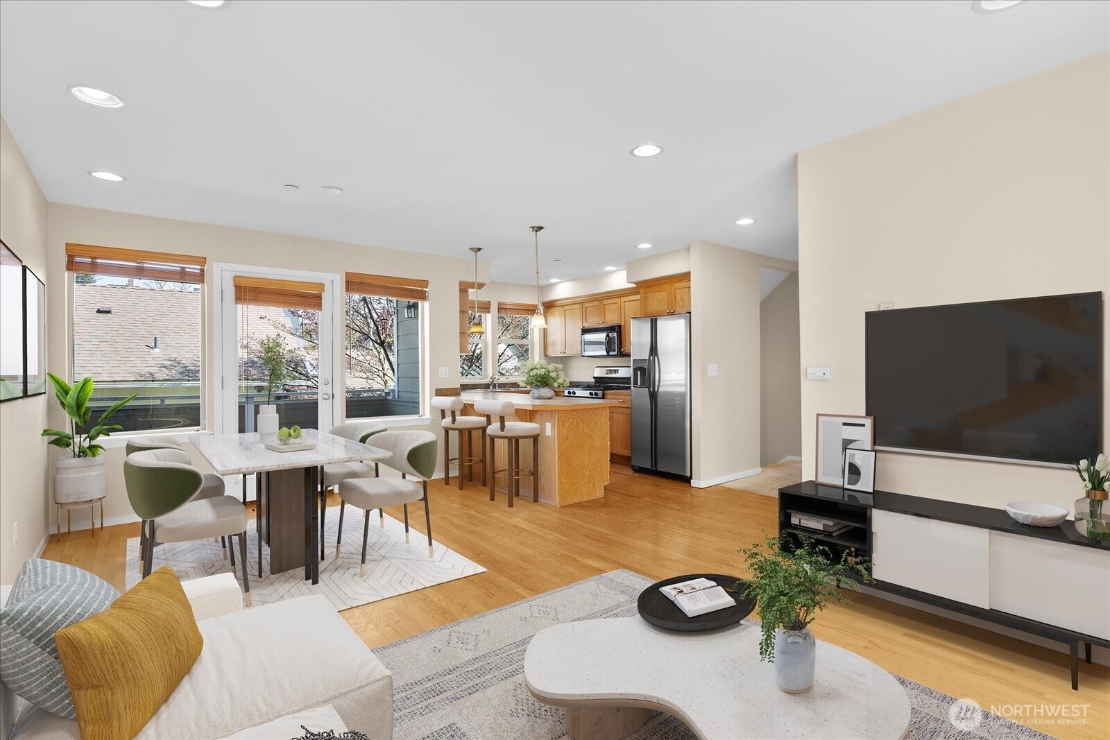Virtually staged living, dining, and kitchen space with wood flooring, modern furnishings, and large windows with blinds.