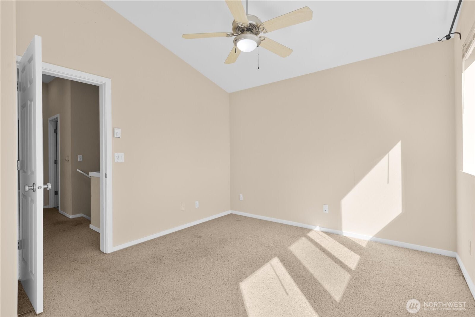 Bedroom with carpeted flooring, ceiling fan, and window allowing natural light.