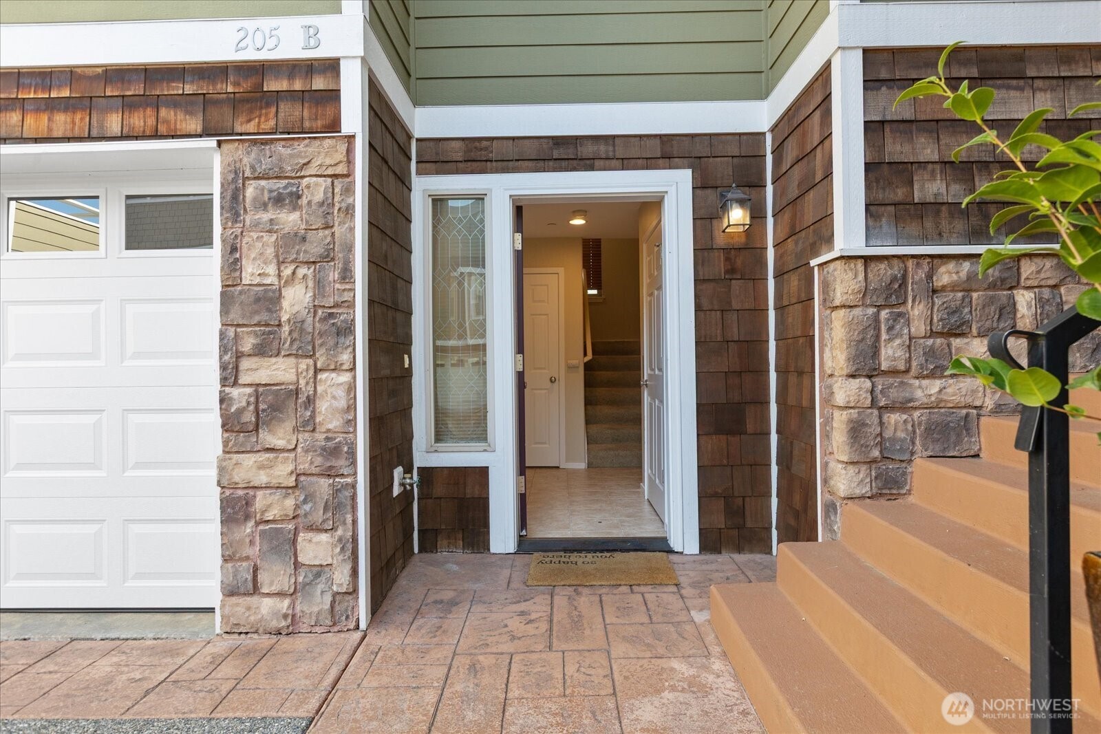 Front entrance, adjacent garage, and stone detailing.