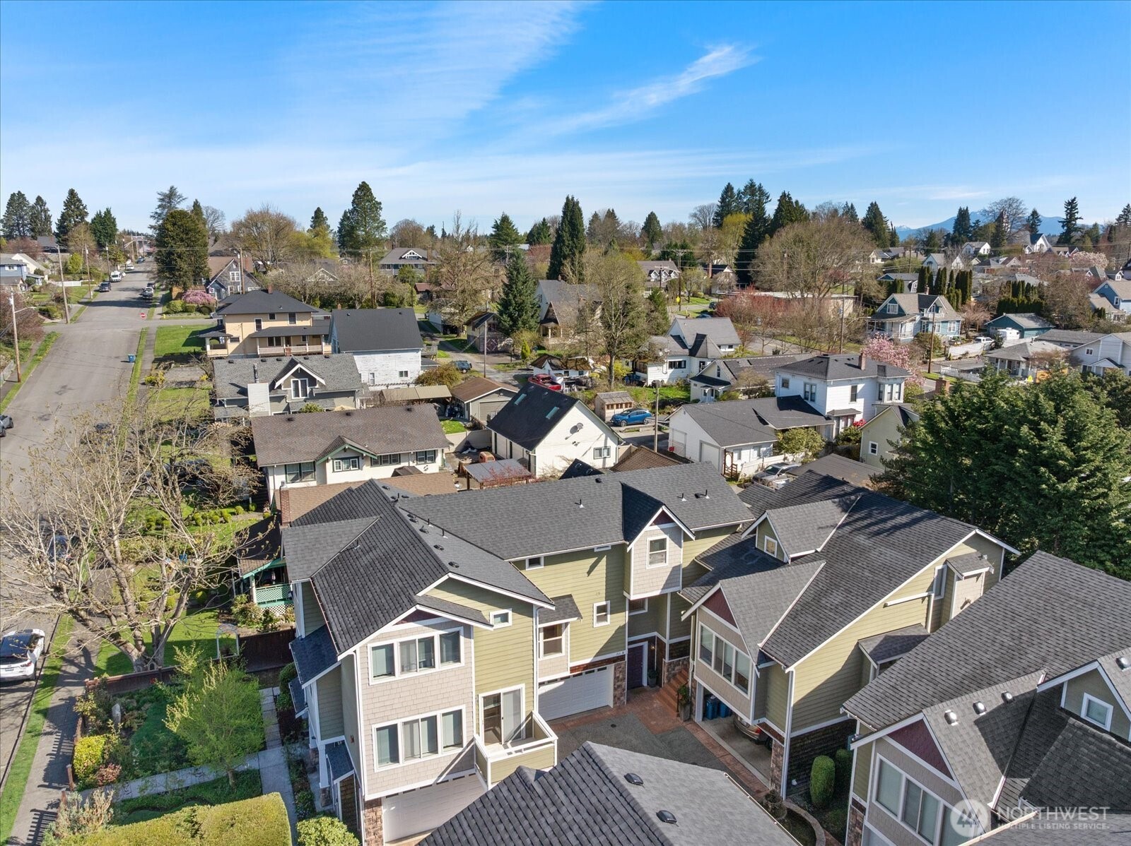 Aerial view of residential neighborhood showing multi-story homes, surrounding streets, and nearby houses.