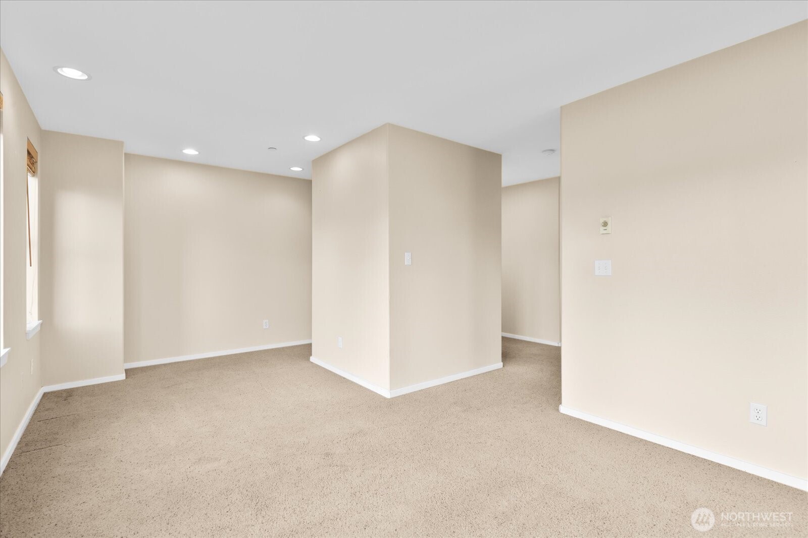 Open flex space with carpeted flooring, recessed lighting, and windows providing natural light.