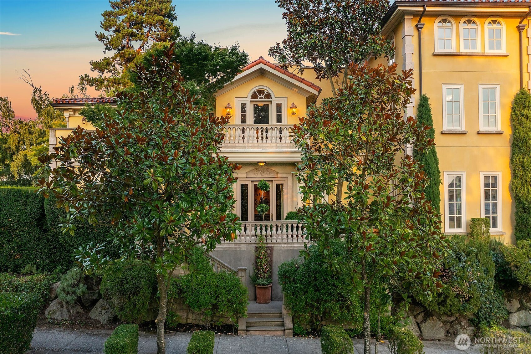 Framed by Magnolia trees, this exquisite home features balustrade-lined balconies and terraces, real stucco exterior, and a tile roof with solar array.