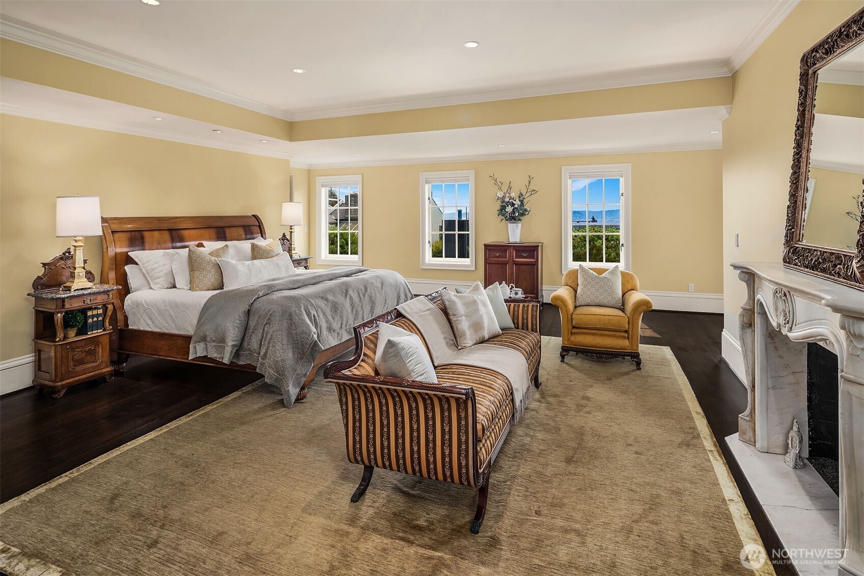 Luxurious primary bedroom with marble gas fireplace, adjoining office/sitting room, 5-piece en-suite bathroom, walk-in closet, and laundry room.