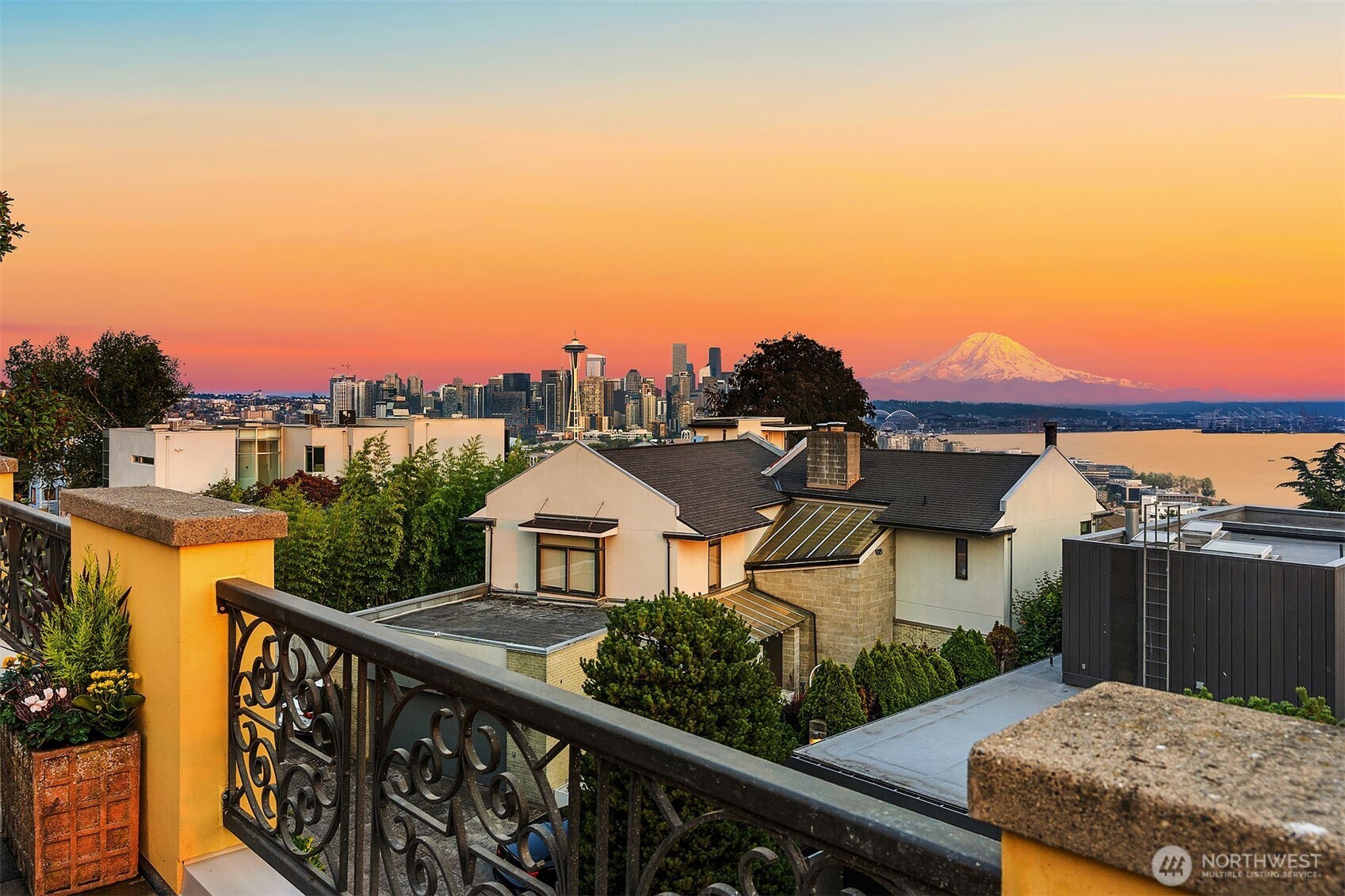 Iconic south-facing view from the rooftop deck of the Seattle city skyline, Mount Rainier, and Puget Sound.