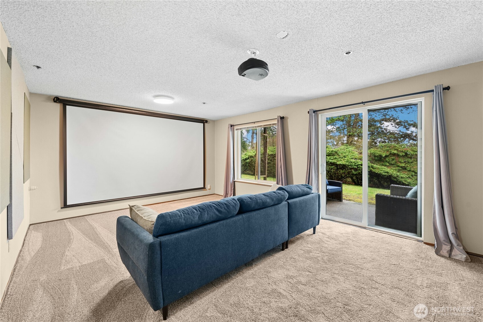 Downstairs family room with full-screen projector unit-stays with home.  Access to shared backyard.