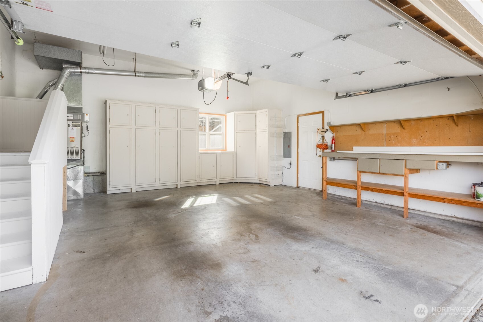 Clean garage with extra storage space above and room for more