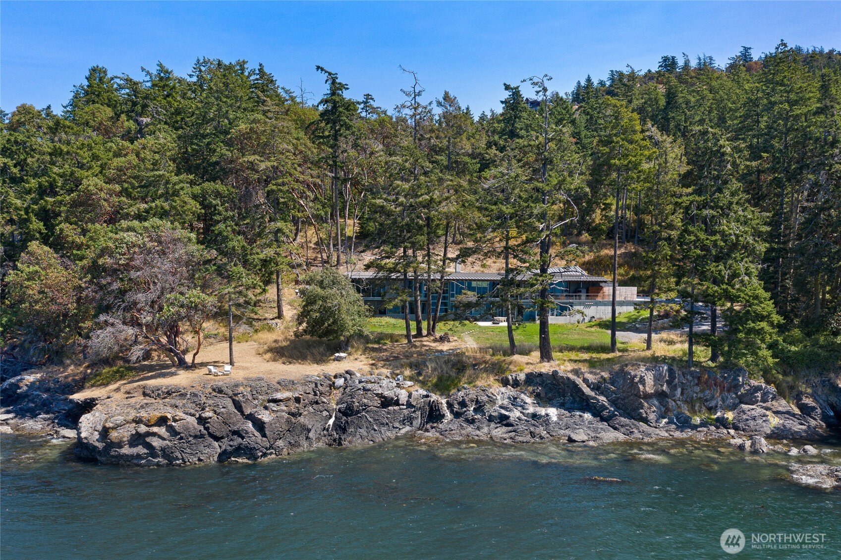 The home’s dramatic architecture unfolds along the shoreline, where floor-to-ceiling glass and natural materials blend seamlessly with the rugged beauty of San Juan Island’s west side waterfront.
