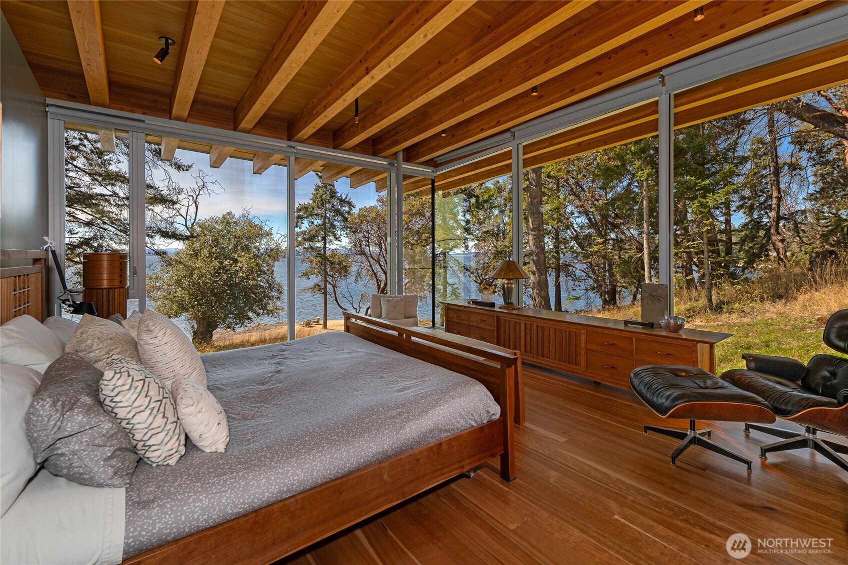 Wake up to breathtaking waterfront vistas from this serene primary suite, where floor-to-ceiling windows blur the line between indoor comfort and the natural beauty of the San Juan Islands.