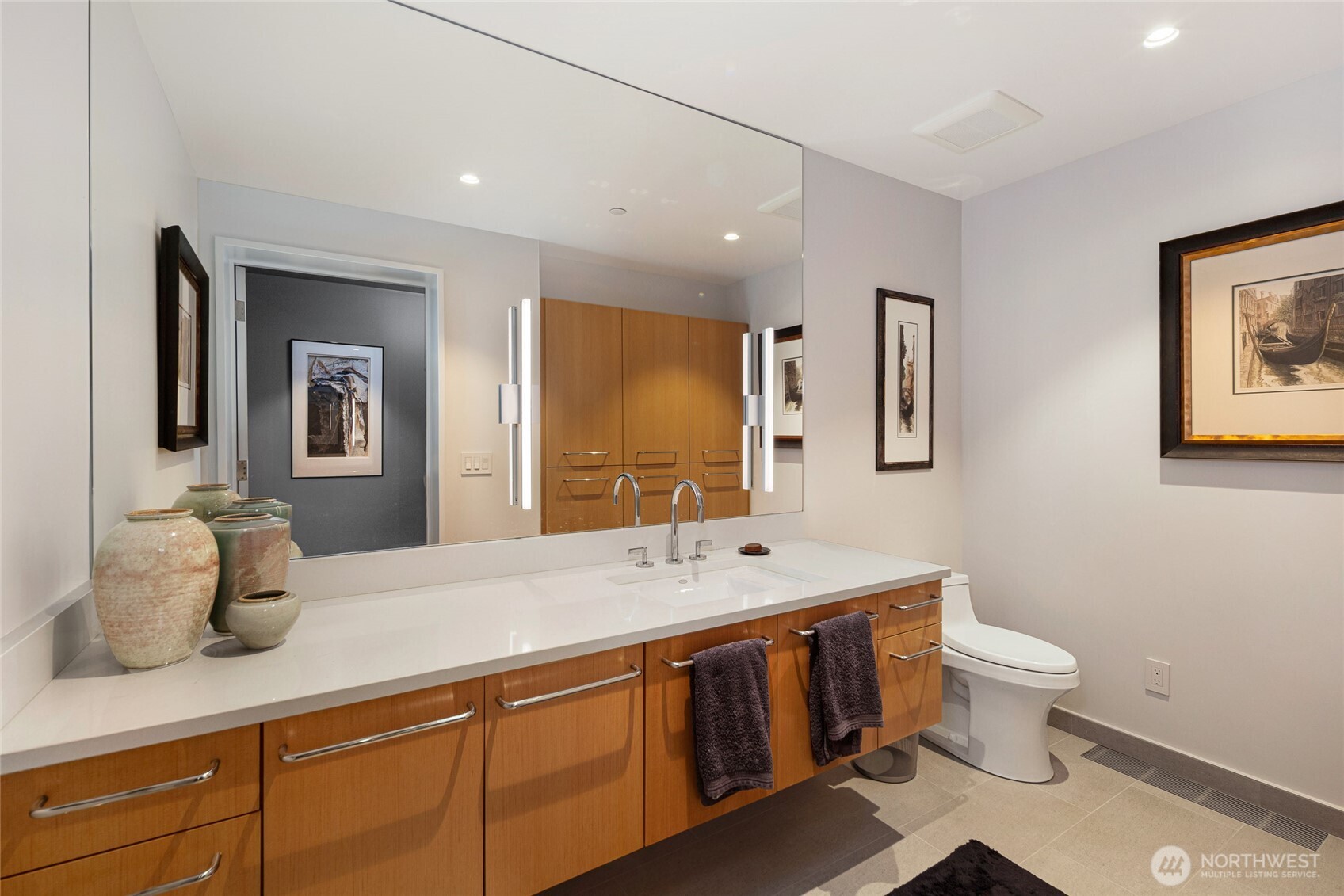 A beautifully appointed bathroom with custom wood cabinetry, sleek quartz counters, and modern lighting, reflecting the home’s consistent attention to detail and craftsmanship.