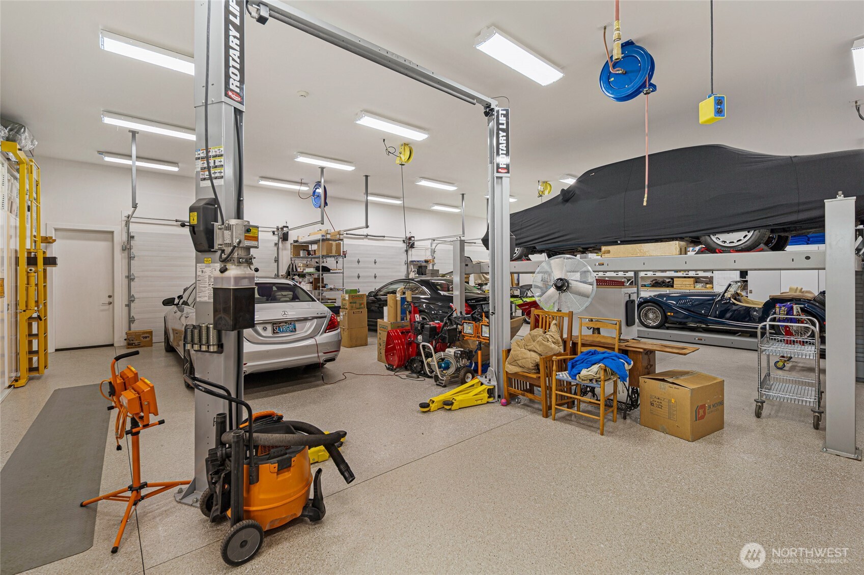 Expansive professional-grade workshop and garage with vehicle lift, high ceilings, and abundant workspace—ideal for collectors, hobbyists, or creative pursuits within this exceptional San Juan Island estate compound.