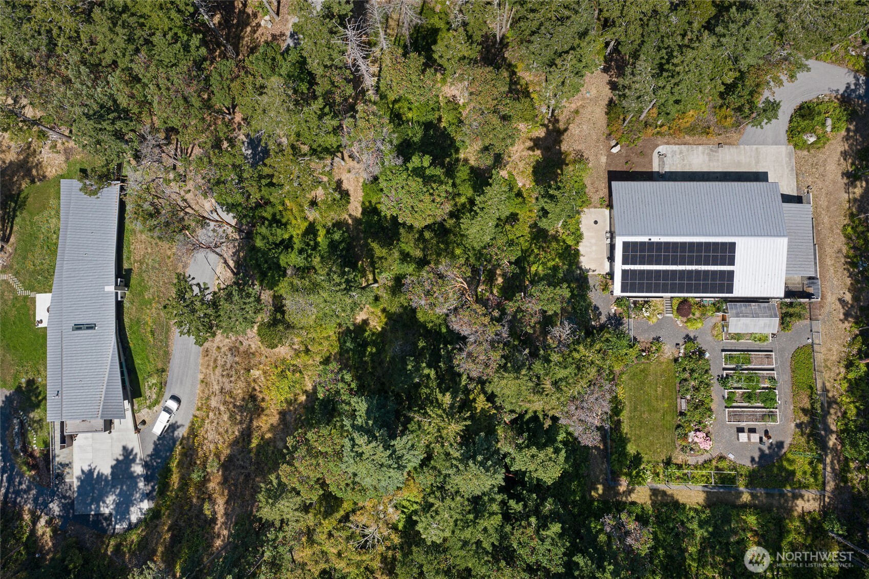 Bird’s-eye view of the estate’s greenhouse, fenced garden beds, and workshop/garage, thoughtfully designed for those seeking luxury San Juan Island living with sustainability and garden-to-table lifestyle.