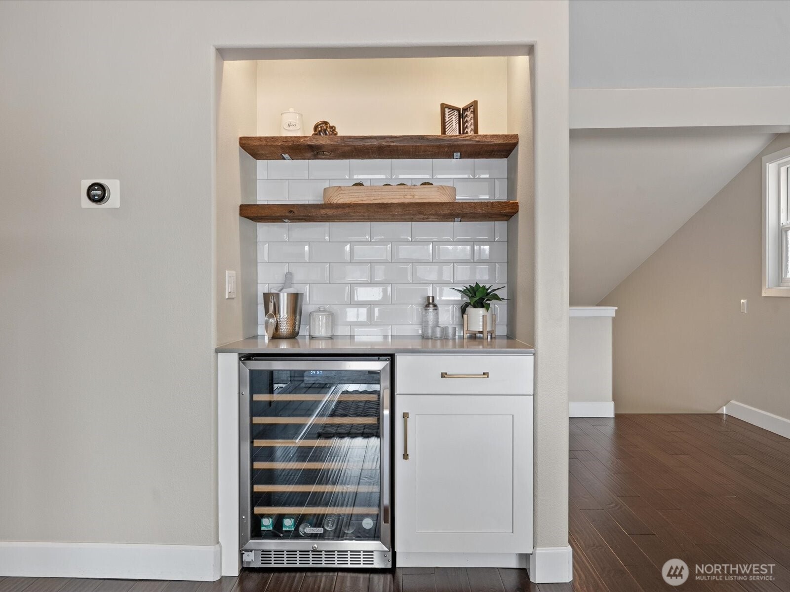 Built-in wet bar with beverage fridge, open shelving, tile backsplash, and countertop workspace