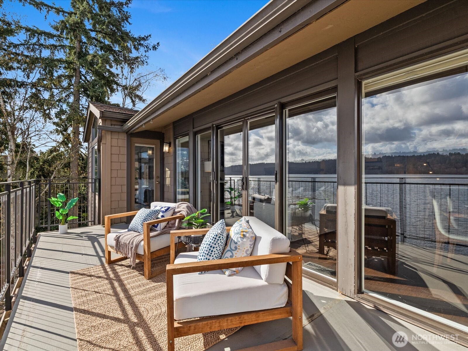 Waterfront deck with sliding glass doors, outdoor seating, and direct Lake Sammamish views