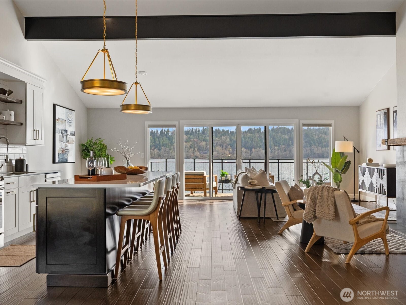 Open-concept living and dining area with hardwood flooring, vaulted ceilings, and large windows with Lake Sammamish views