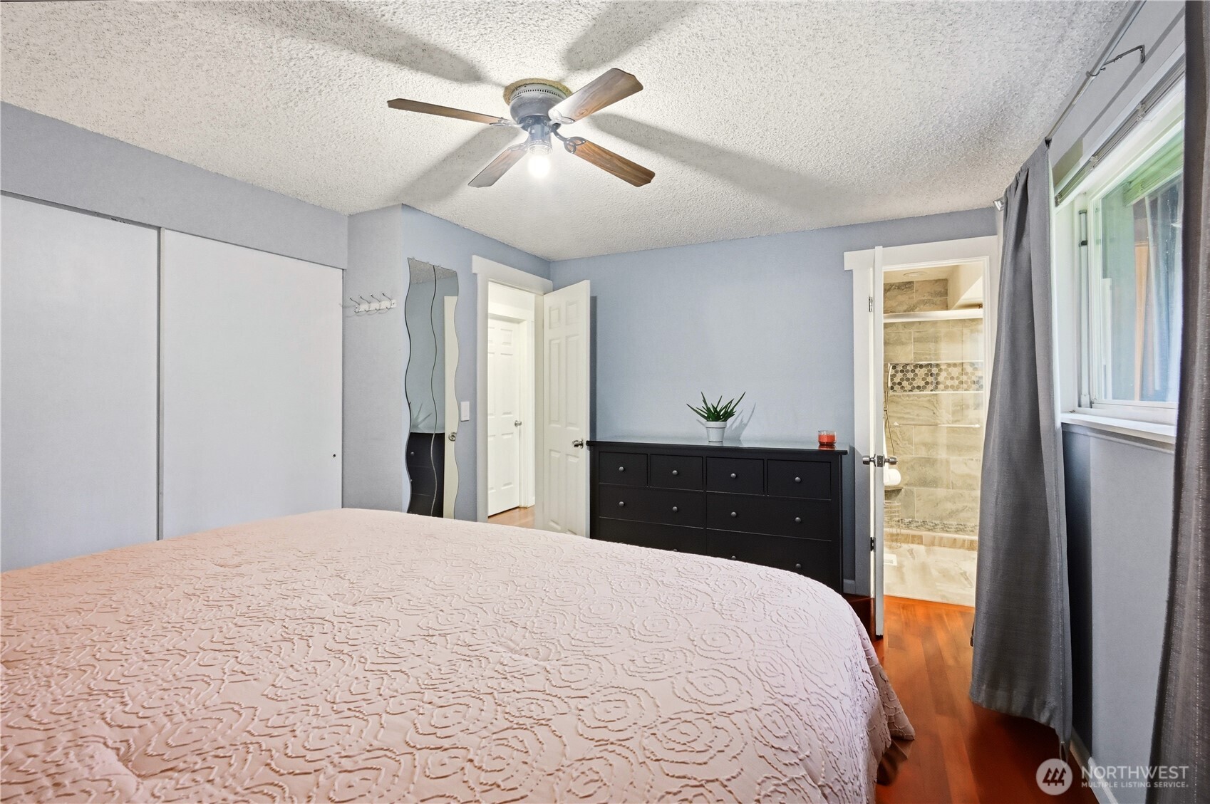 Spacious primary bedroom with ceiling fan, ready for your personal touch.