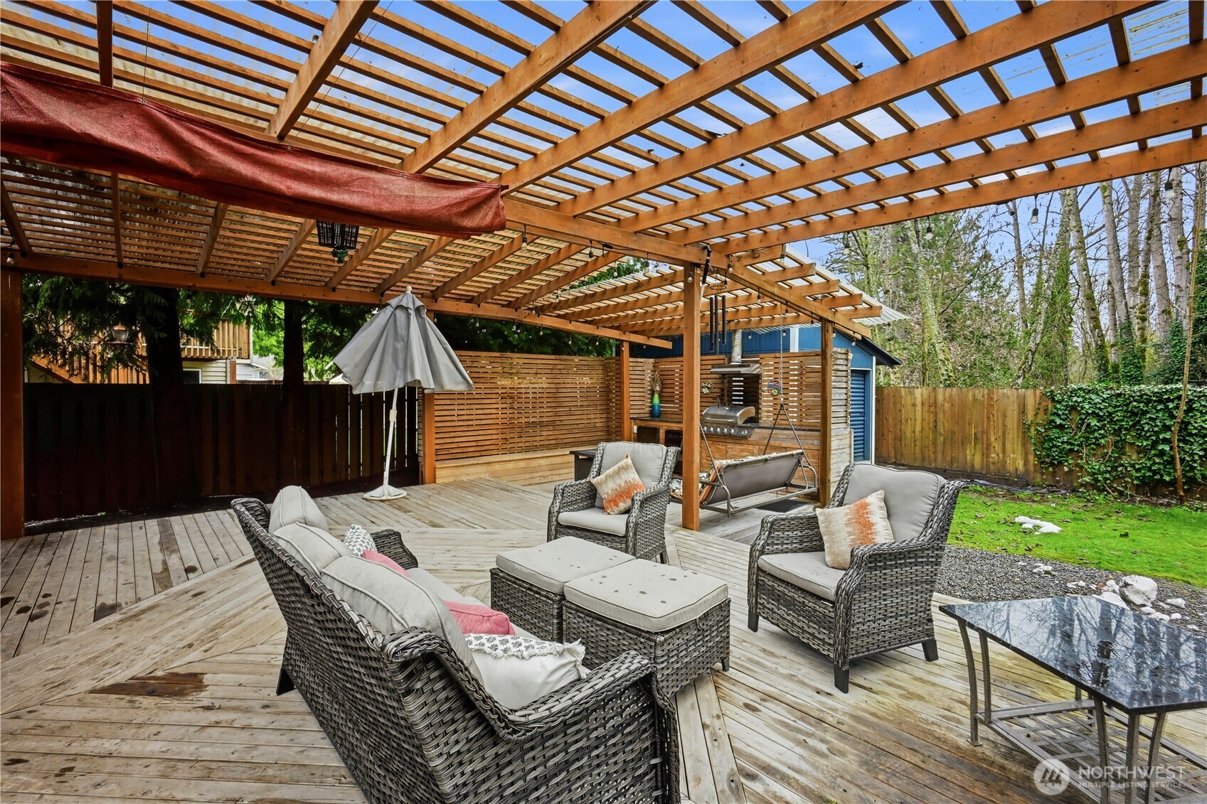 Expansive outdoor living area under a wood pergola, ideal for year-round entertaining.