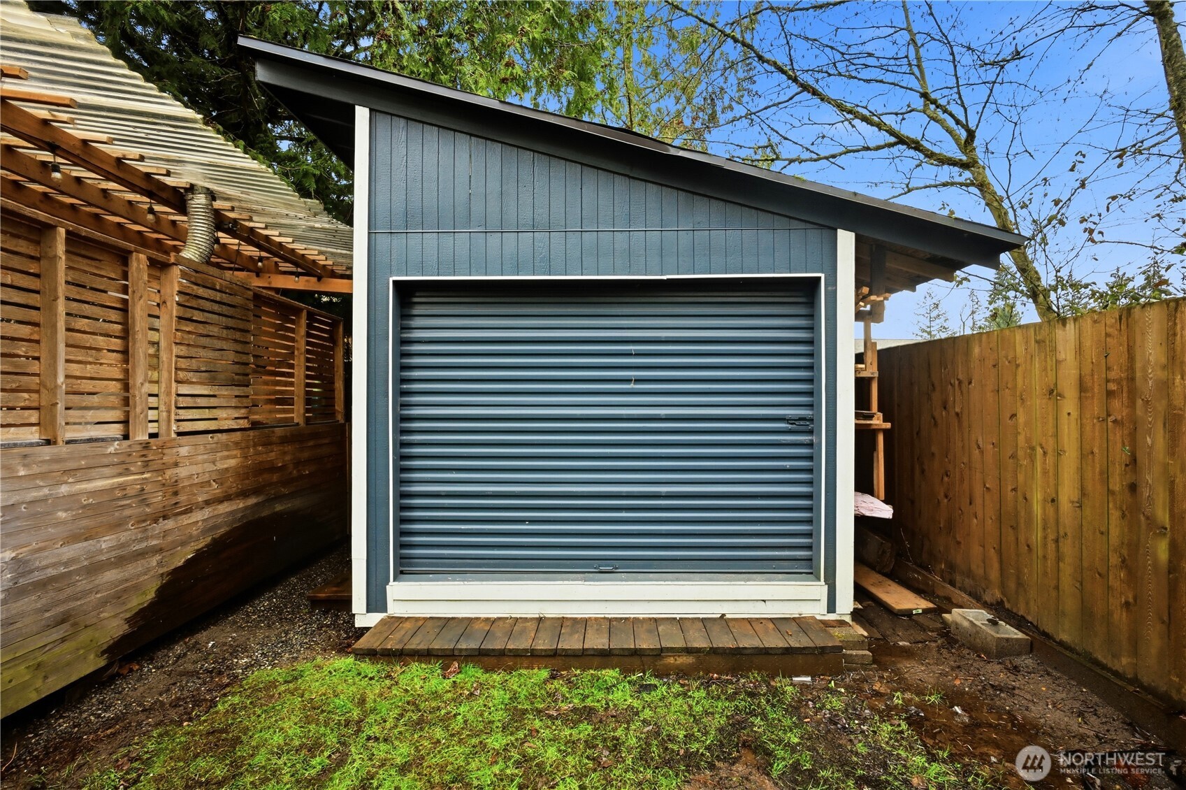 Versatile detached outbuilding with a modern roll-up door, great for a creative studio, or additional storage.