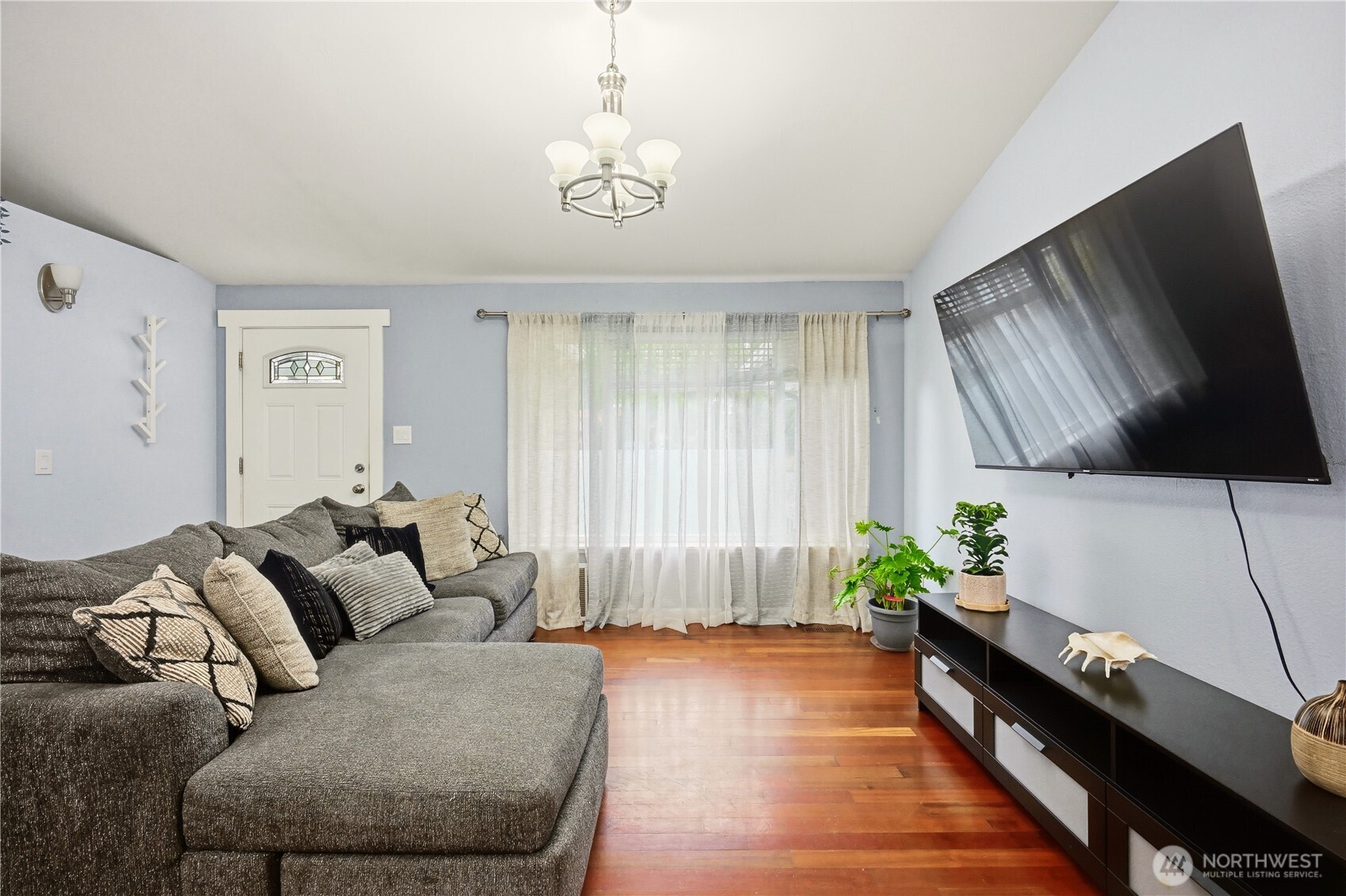 Spacious living area with engineered hardwood floors and plenty of natural light.