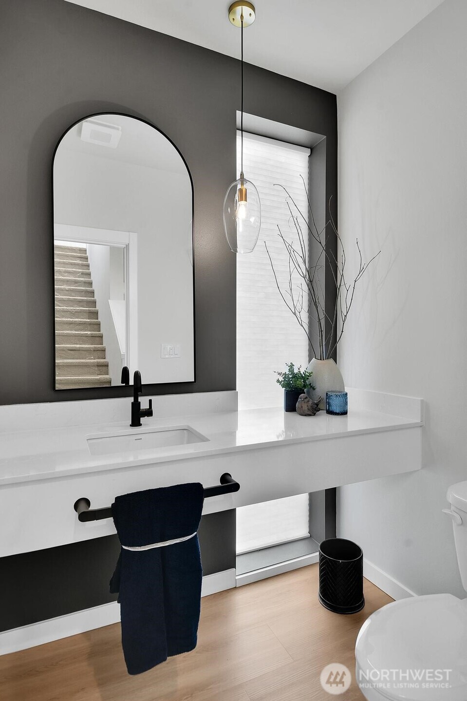 The half bath on the main floor is stunning with a floating vanity and floor to ceiling window.