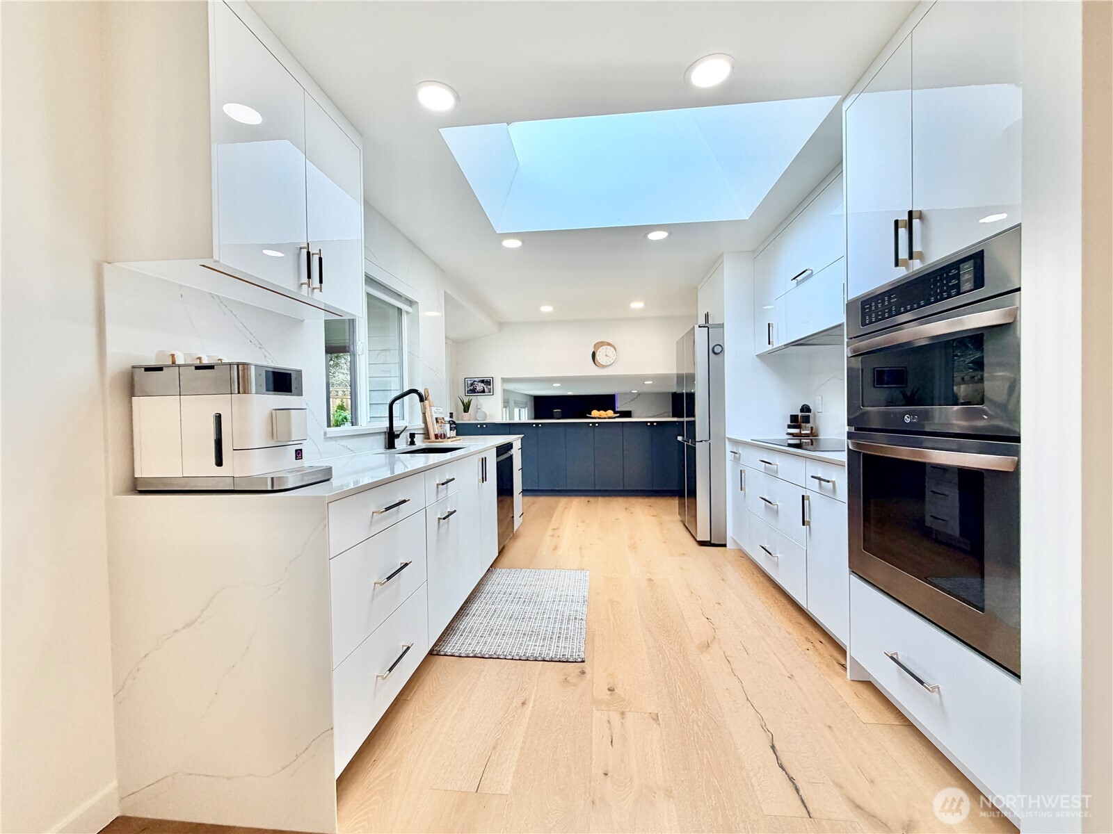 Upgraded kitchen features 3cm quartz countertops/ island, new plywood core frameless cabinets, and new stainless-steel appliances