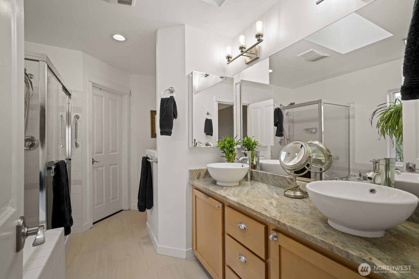 Updated 5 piece bathroom with soaking tub, tiled shower, 12 x 24 tiled floors and dual vanities with vessel sinks.