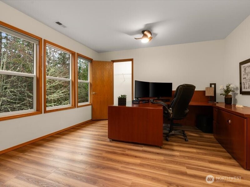 Ease of work environment from home office, off primary suite, offering tranquil views of backyard and wooded greenbelt area