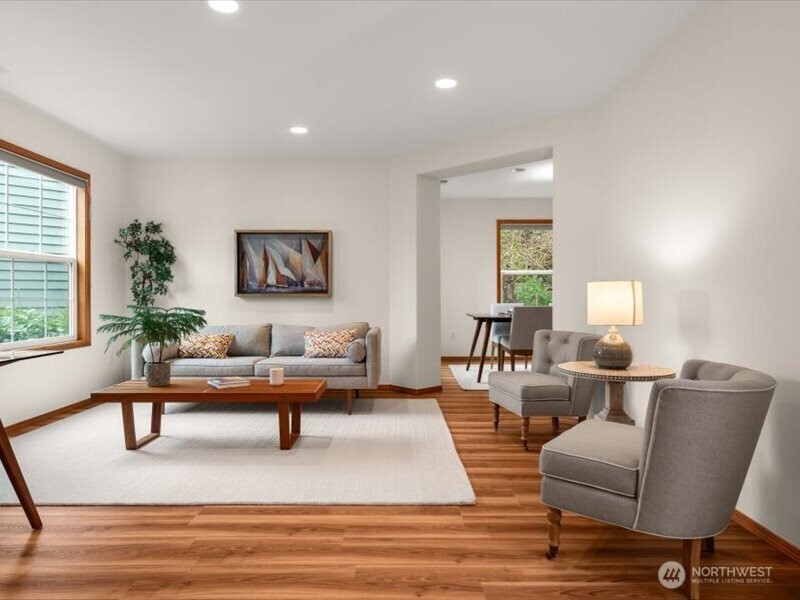 Sunlit living room with large front windows illuminating light throughout