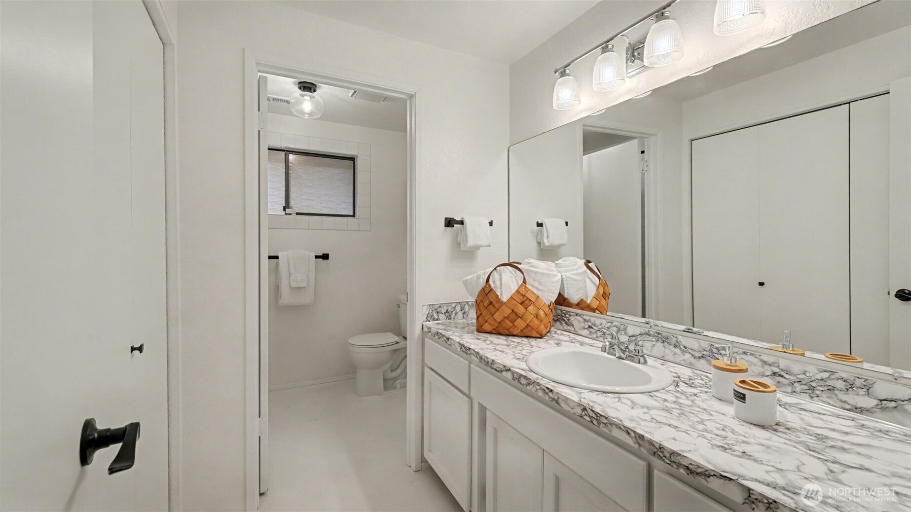 A bright and refreshed guest bath featuring a spacious vanity and a separate water closet for added privacy.